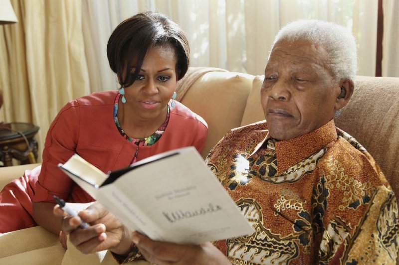 First lady Michelle Obama visits with former South African President Nelson Mandela at his home in Houghton, South Africa, in this June 21, 2011, photo. 