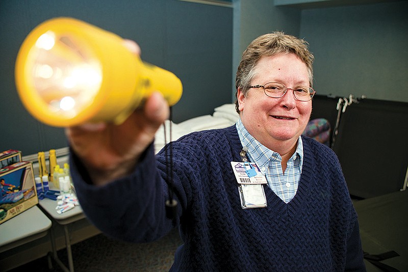 Kathleen Blackwell, safety and regulatory manager at Saline Memorial Hospital, holds a flashlight that is among the supplies employees can use during weather conditions that require them to stay at the hospital instead of going home.