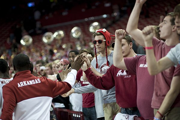 Arkansas fans congratulate players following an NCAA college basketball game in Fayetteville, Ark., Monday, Nov. 18, 2013. Arkansas beat SMU 89-78. (AP Photo/Sarah Bentham)