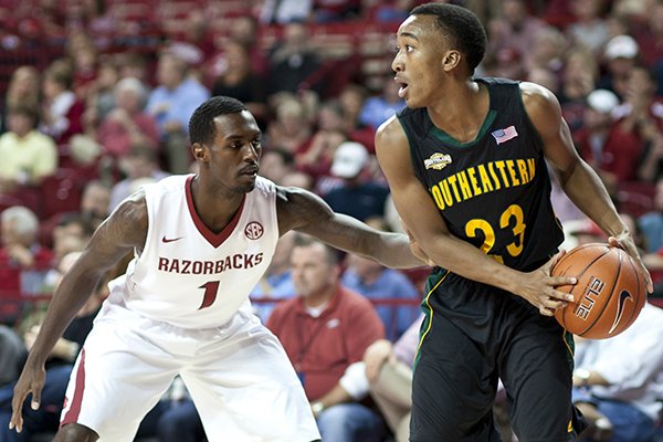 Southeastern Louisiana's Joshua Filmore (23) looks to pass the ball as Arkansas' Mardracus Wade (1) defends during the first half of an NCAA college basketball game in Fayetteville, Ark., Tuesday, Dec. 3, 2013. (AP Photo/Sarah Bentham)