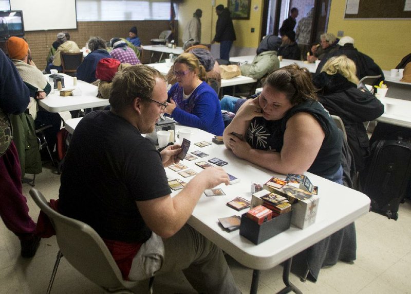 Brandon Wheeler and his sister Samantha play Magic: The Gathering on Friday at the Salvation Army’s warming center on Markham Street in Little Rock. 