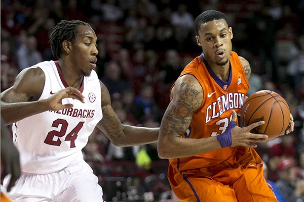 Clemson forward K.J. McDaniels, right, drives to the basket against Arkansas guard Michael Qualls during the first half of a NCAA college basketball game against Clemson Saturday, Dec. 7, 2013, at Bud Walton Arena in Fayetteville, Ark. (AP Photo/Gareth Patterson)