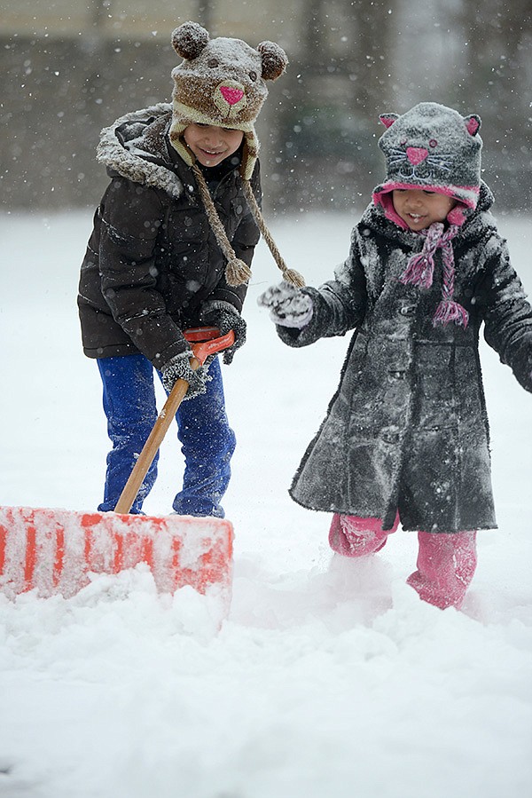 Jocelyn Trejo, 7, left, and Pamela Trejo, 4, shovel snow Friday outside their apartment in Springdale. The pair, along with their father, were gathering snow to build a snowman. The family found a little fun after a winter storm closed area schools and many businesses.
FAMILY FUN 