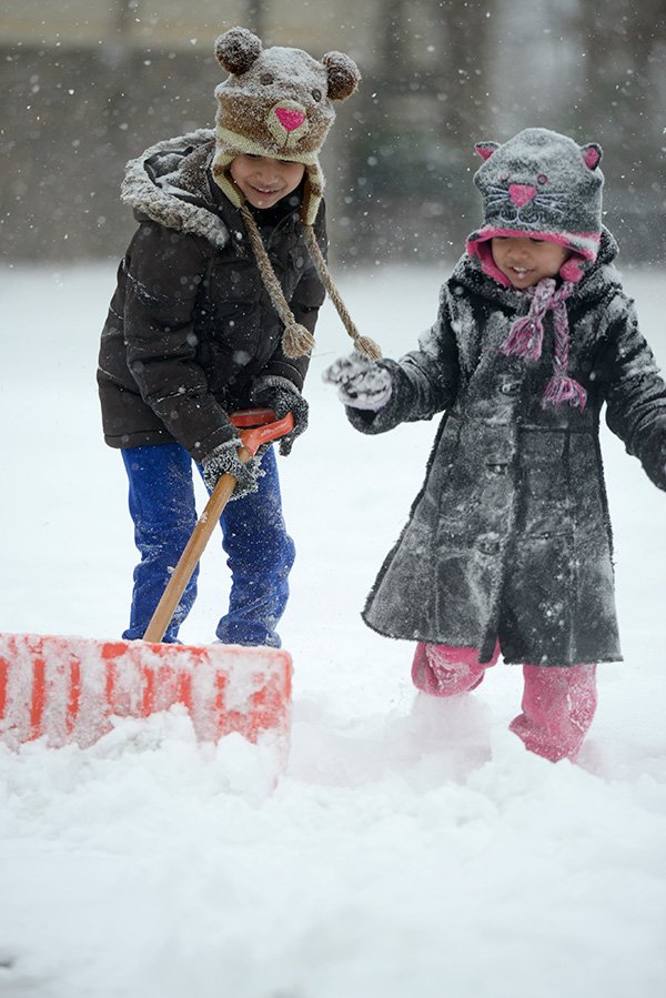 Jocelyn Trejo, 7, left, and Pamela Trejo, 4, shovel snow Friday outside their apartment in Springdale. The pair, along with their father, were gathering snow to build a snowman. The family found a little fun after a winter storm closed area schools and many businesses.
FAMILY FUN 