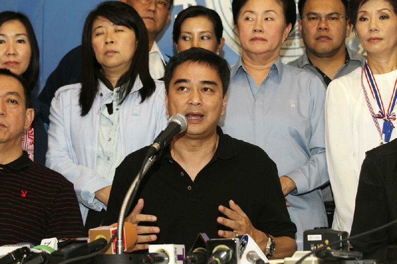 Democrat leader and former Prime Minister Abhisit Vejjajiva speaks along with his party members during a press conference in Bangkok, Thailand, Sunday, Dec. 8, 2013. The main opposition party announced it was resigning from parliament to protest what it called "the illegitimacy" of the government. The move deepens the country's latest political crisis a day before new street demonstrations that many fear could turn violent. (AP Photo/Sakchai Lalit)