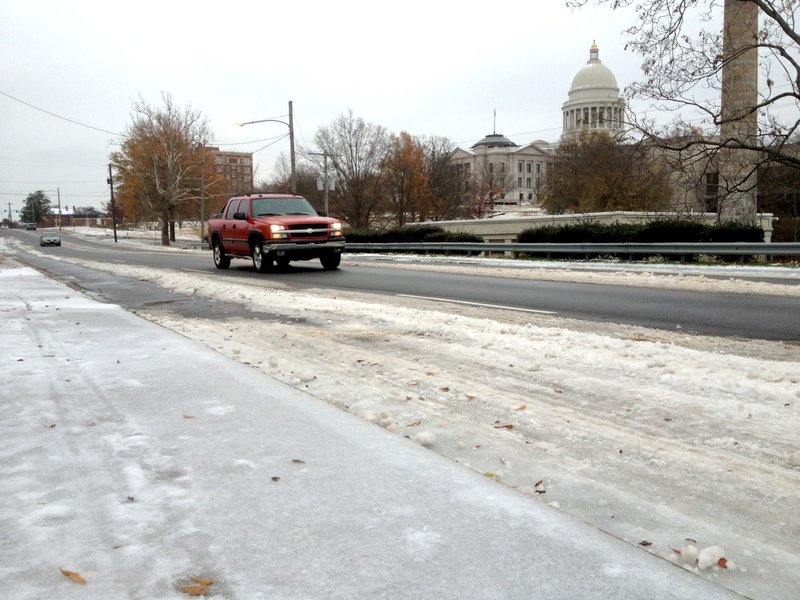 Drivers negotiate slushy roads Monday, Dec. 9, 2013, on Third Street near the state Capitol in Little Rock.