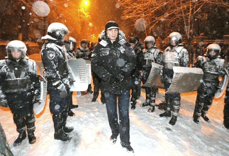 Ukrainian lawmaker and chairman of the opposition party Udar (Punch), WBC heavyweight boxing champion Vitali Klitschko surrounded by police trying to stop the possible collisions between police and Pro-European Union activists in Kiev, Ukraine, on Monday, Dec. 9, 2013.