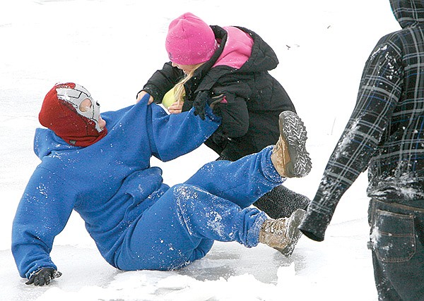 STAFF PHOTOS DAVID GOTTSCHALK 
Jenn Terry (left), grabs her daughter Laurien Terry (right), 8, as she slips and falls while attempting to dance on ice Monday afternoon in Rogers. The two were also playing with her son Jasper, 12, his friend Alex Adam, 9, and his sister Isabel Salazar, 7.