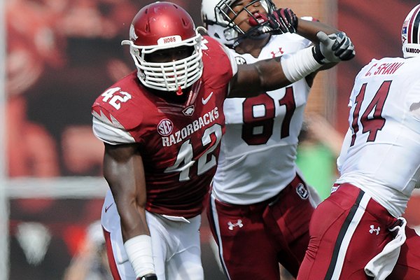 Arkansas's Chris Smith, left, charges after Connor Shaw of South Carolina Saturday, Oct. 12, 2013, during the second quarter of the game against South Carolina at Donald W. Reynolds Razorback Stadium in Fayetteville.