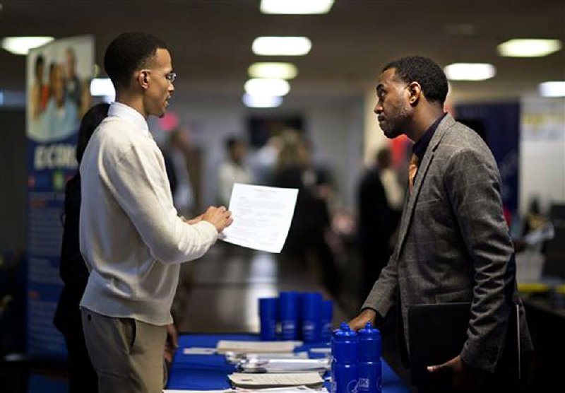 Ralph Brown (left), a manager with the Centers for Disease Control and Prevention, looks at the resume of retired U.S. Air Force Master Sgt. Thomas Gipson at a job fair in Marietta, Ga., in November. The Labor Department said job openings reached a five-year high in October. 