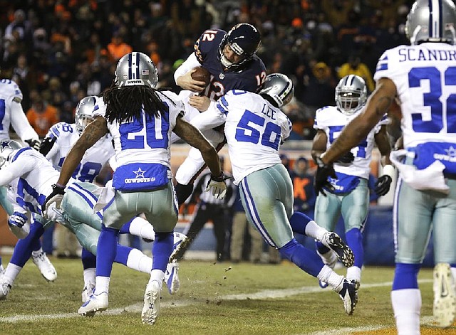 Chicago quarterback Josh McCown (12) gets hit by Dallas linebacker Sean Lee (50) in the air while scoring a touchdown in the first half of the Bears’ 45-28 victory Monday night at Soldier Field in Chicago. The Cowboys have allowed at least 490 yards in fi ve games, which ties the 1965 Houston Oilers and 1950 Baltimore Colts for the most since 1950. 