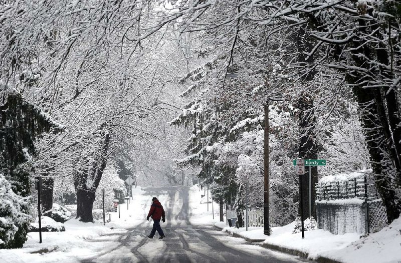 A man crosses a snowy road in Towson, Md., on Tuesday. 