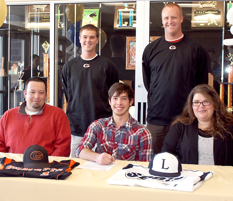 Photo by Dodie Evans Wyatt Gibbons, center, is flanked by his parents, Tim and Stephanie Gibbons, as he signs to play baseball with the Lyon College Scots. GHS baseball coach Randall Hunt, left, a...