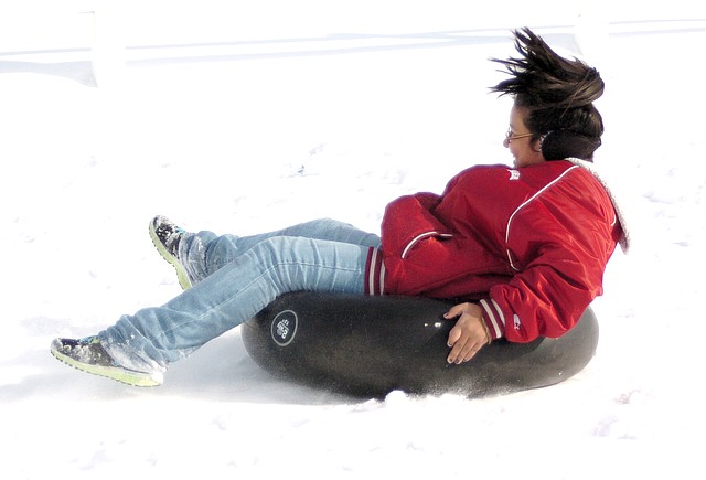 Photo by Randy Moll Lania Perez, 11, rides an inner tube down a snow-covered hill in Gentry on Saturday, Dec. 7, 2013....