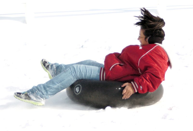 Photo by Randy Moll Lania Perez, 11, rides an inner tube down a snow-covered hill in Gentry on Saturday, Dec. 7, 2013....