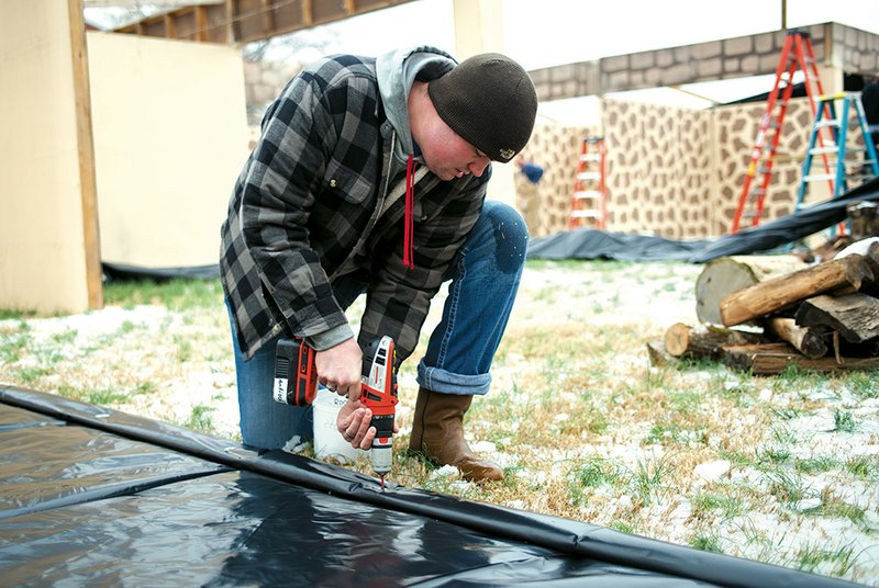 Nathan Brewer drives screws into a roof panel to finish building Bethlehem Revisited, the living Nativity at Antioch Baptist Church, 150 Amity Road in Conway. The production will be held from 6:30-8:30 p.m. today and Friday.