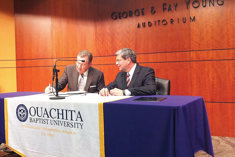 Ouachita Baptist University President Rex Horne, left, and U.S. Rep. Mike Ross, D-Ark., sign an agreement for the congressman to donate his official papers to Ouachita’s archives collection.