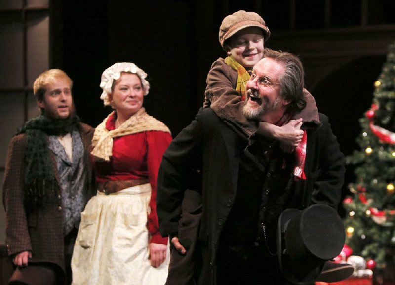 NWA Media/DAVID GOTTSCHALK 12/11/13 - Ebenezer Scrooge, played by Jeffrey Baumgartner, carries Tiny Tim, played by Noah Chacon, into the Cratchit family home during the ending scenes of A Christmas Carol performed at TheatreSquared Wednesday afternoon Dec. 11, 2013 in Fayetteville.
