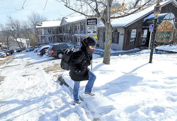 STAFF PHOTOS ANDY SHUPE 
Sonia Kapur, a doctoral student at the University of Arkansas from India, walks through ice and snow Wednesday in the parking lot of her apartment complex at 630 N. Leverett Ave. in Fayetteville.