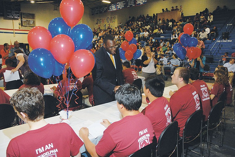 Glen Jones, standing, president of Henderson State University in Arkadelphia, congratulates students signing to attend HSU during a May 21 ceremony for Arkadelphia Promise Scholarship recipients at Arkadelphia High School. The Promise program and HSU have both worked to enhance student funding following Arkansas Lottery scholarship cuts.