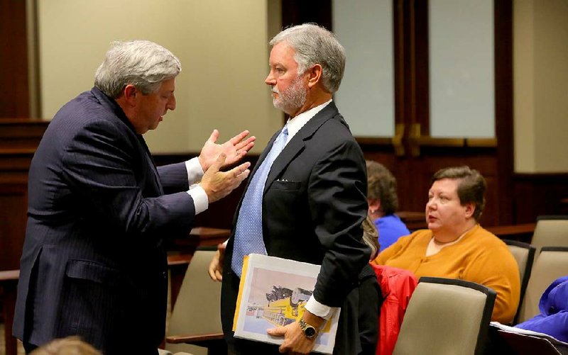 University of Arkansas trustee John Goodson (left) talks with Brad Choate, former UA vice chancellor for advancement, after Goodson told legislators Friday that the university had adopted state auditors’ recommendations after their review of the Advancement Division’s deficit. 