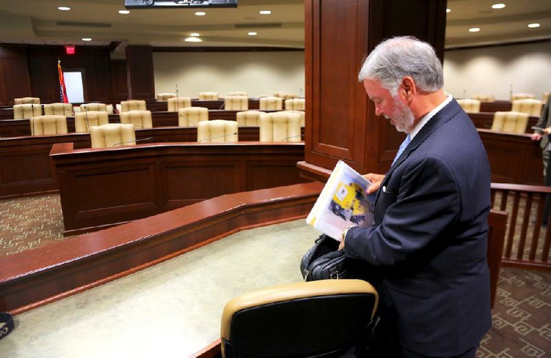 Brad Choate, former vice chancellor for advancement at the University of Arkansas at Fayetteville, packs away a notebook decorated with a “thrown under the bus” theme Friday after the Legislative Joint Auditing Committee accepted an audit report without hearing from him about the division’s deficit. 