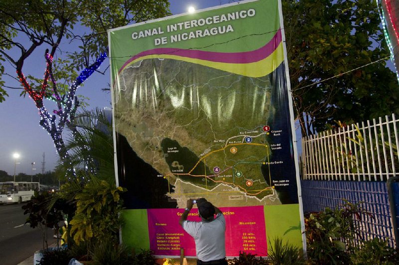 Oscar Torres, a retired construction worker, takes photos earlier this month of a map of potential routes of a new canal across Nicaragua. 