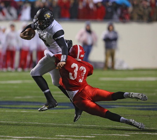 Bentonville's QB Kasey Ford, scrambles upfield for a first down but is finally brought down by Cabot's Jacob Ferguson  in the first half during their class 7a championship game Friday night at War Memorial Stadium in Little Rock.