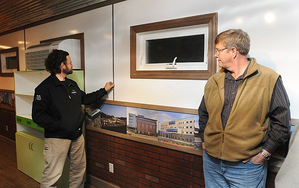 Flint Richter, left, system designer with Rocky Grove Sun Company, and Greg Fogle, president of midwest operations for Nabholz Construction Services, inspect the whiteboard walls in the environmentally-friendly job site trailer Friday, Dec. 13, 2013, at Nabholz Industrial Services in Rogers. Nabholz Construction Servies unveiled the on-site mobile office, which was built in-house, Friday.