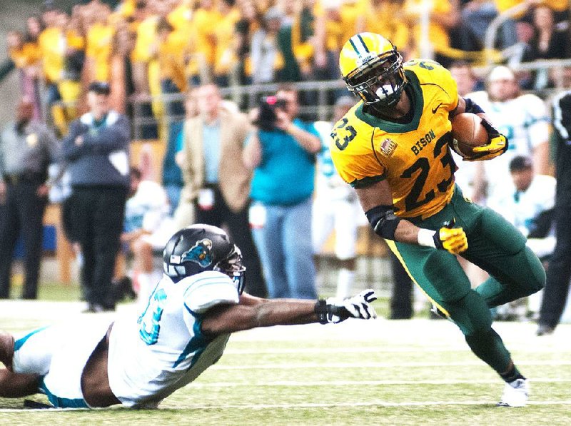 North Dakota State running back John Crockett (23) eludes Coastal Carolina defender Dominique Whiteside during an NCAA college football game in the quarterfinals of the Football Championship Subdivision playoffs Saturday, Dec. 14, 2013, in Fargo, N.D. (AP Photo/Kevin Cederstrom)