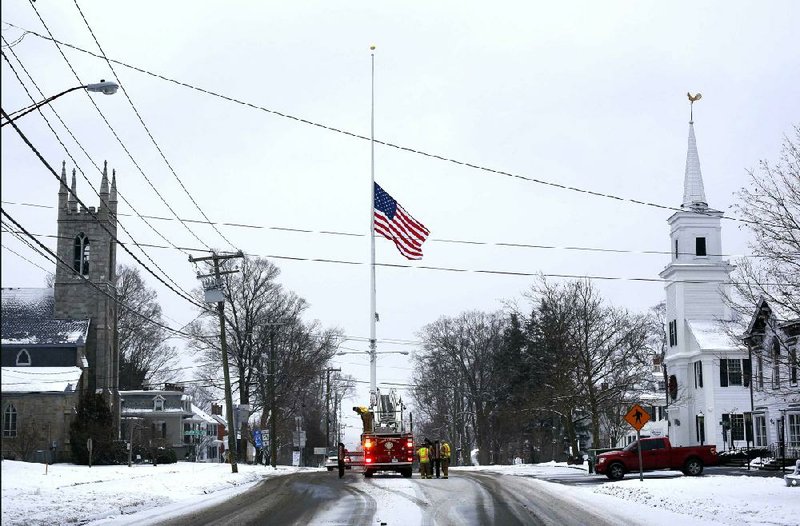 On the first anniversary of the Sandy Hook massacre, firefighters lower the town's flag on Main Street to half-staff in honor of the victims, Saturday, Dec. 14, 2013, in  Newtown, Conn.  (AP Photo/Robert F. Bukaty)