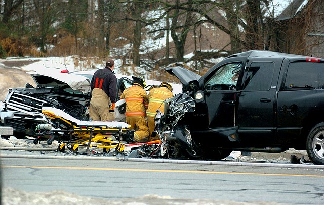 Photo by Randy Moll Gentry firefighters work to free an accident victim trapped Saturday, Dec. 14, 2013, in a pickup truck following a head-on collision on Arkansas 59 south of Gentry.