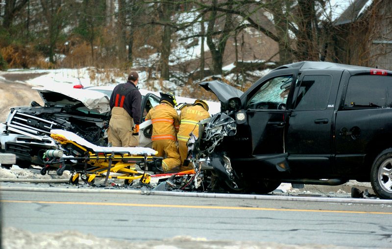 Photo by Randy Moll Gentry firefighters work to free an accident victim trapped Saturday, Dec. 14, 2013, in a pickup truck following a head-on collision on Arkansas 59 south of Gentry.