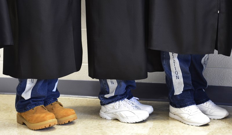 In this Dec. 13, 2013 photo, inmates at the Tennessee Prison for Women in Nashville, Tenn., wear graduation gowns over their prison uniforms for their graduation ceremony. Nine inmates earned an associates degree through Lipscomb University, carrying a collective GPA of 3.7. (AP Photo/Mark Zaleski)