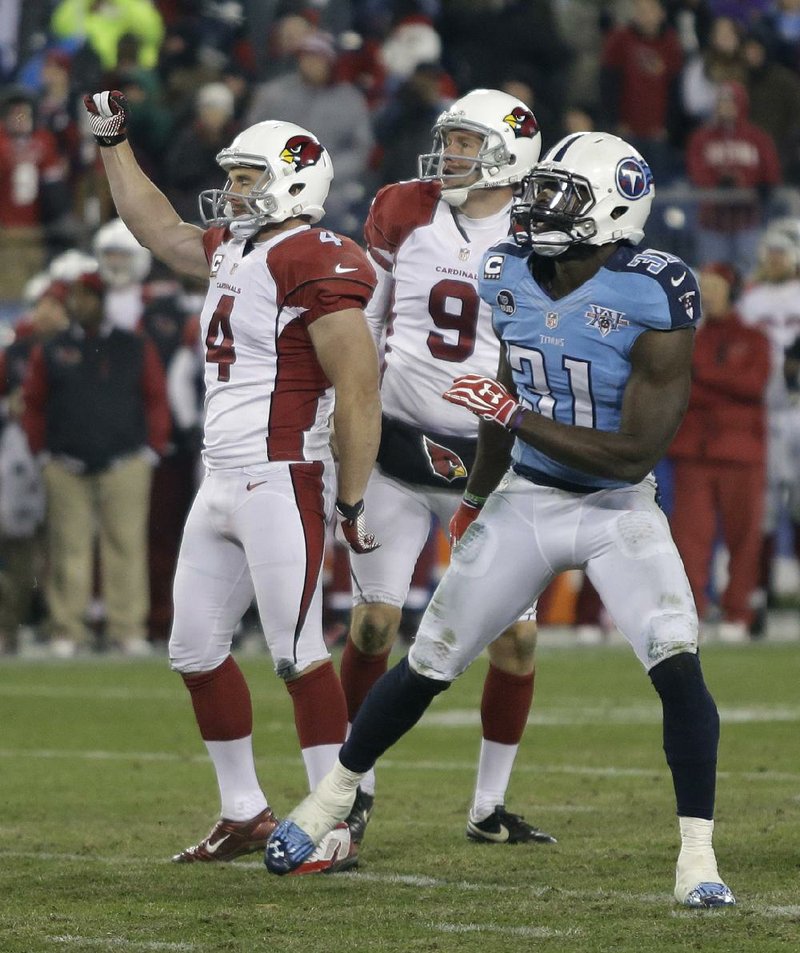 Arizona Cardinals kicker Jay Feely (4) celebrates as holder Dave Zastudil (9) and Tennessee Titans safety Bernard Pollard (31) watch the ball after Feeley kicked a 41-yard field goal in overtime against the Tennessee Titans to give the Cardinals a 37-34 win in an NFL football game Sunday, Dec. 15, 2013, in Nashville, Tenn. (AP Photo/Wade Payne)