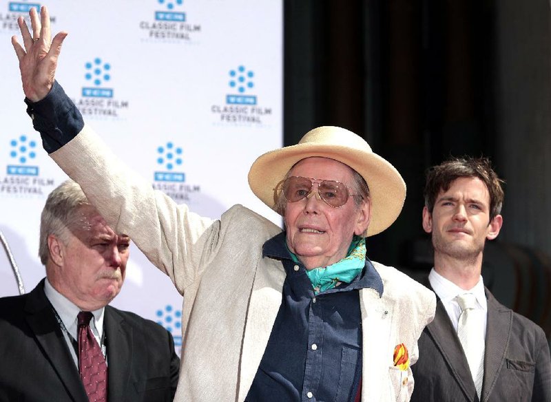 FILE - In this April 30, 2011 file photo, Actor Peter OToole, center, waves to fans as his son Lorcan O'Toole, right, looks on as Peter OToole is honored during the TCM Classic Film Festival at Graumans Chinese Theatre in Los Angeles.  O'Toole, the charismatic actor who achieved instant stardom as Lawrence of Arabia and was nominated eight times for an Academy Award, has died. He was 81. O'Toole's agent Steve Kenis says the actor died Saturday, Dec. 14, 2013 at a hospital following a long illness.(AP Photo/Jason Redmond)