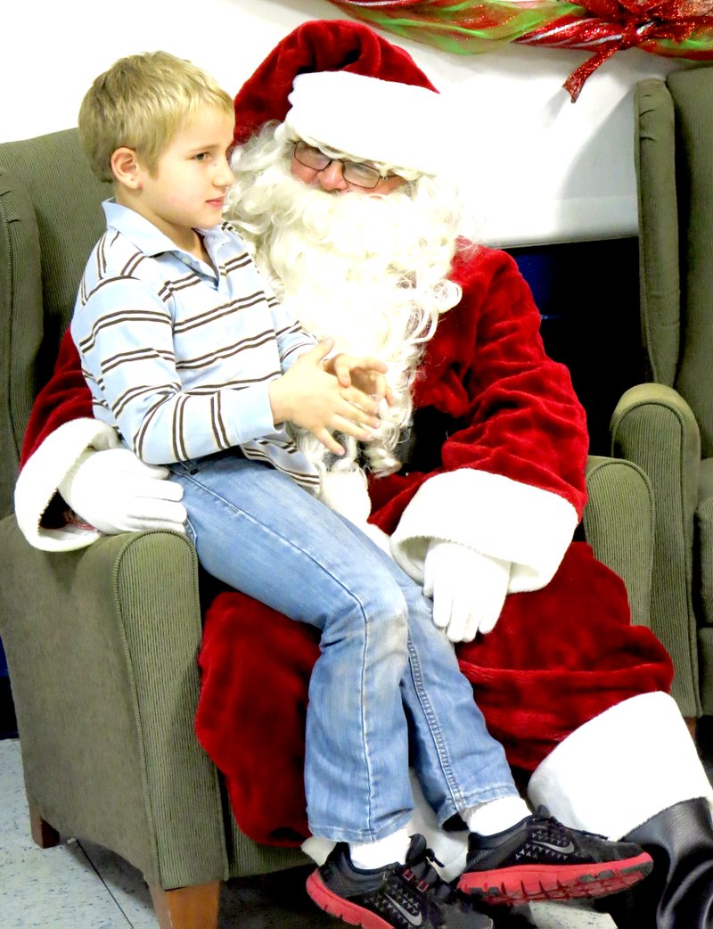 Photos by Mike Eckels A young boy visited with Santa Claus during the Decatur Christmas Festival on Dec. 14 in the high school cafeteria. The youngster was relaying his Christmas list to the jolly old elf himself.