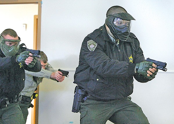 STAFF PHOTO DAVID GOTTSCHALK 
Jonathan Lunsford, right, Washington County Sheriff deputy, is backed up Thursday by Deputy Scott Sharp, left, and Deputy Josh Rhodes, center, as they participate in a tactical force-on-force drill at the Tactical Training Center in Fayetteville.
