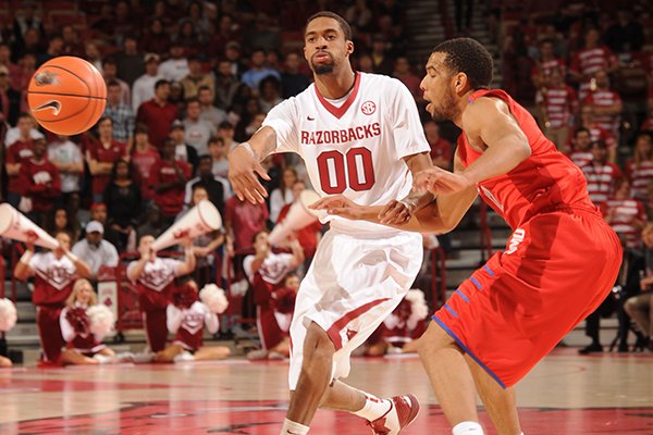 Arkansas guard Rashad Madden (00) passes around Southern Methodist guard Nick Russell during the first half of play Monday, Nov. 18, 2013, in Bud Walton Arena in Fayetteville.