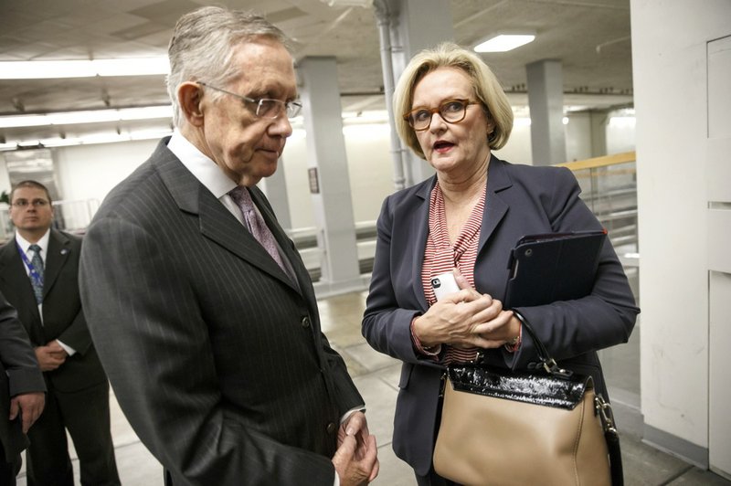 Senate Majority Leader Harry Reid of Nev. speaks to Sen. Claire McCaskill, D-Mo., right, on Capitol in Washington, Tuesday, Dec. 17, 2013, as lawmakers come and go from the Senate after a bipartisan budget compromise cleared a procedural hurdle, advancing past a filibuster threshold on a 67-33 vote that ensures the measure will pass the Democratic-led chamber no later than Wednesday and head to the White House to be signed into law. When enacted, the measure would ease for two years some of the harshest cuts to agency budgets required under automatic spending curbs commonly known as sequestration. 