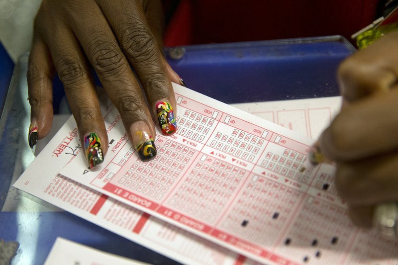 A woman fills out a form to buy a Mega Millions ticket at The Gallery Shop in Washington, Tuesday, Dec. 17, 2013. The Mega Millions jackpot soared to an estimated $636 million on Tuesday, making it the second largest lottery jackpot in U.S. history.