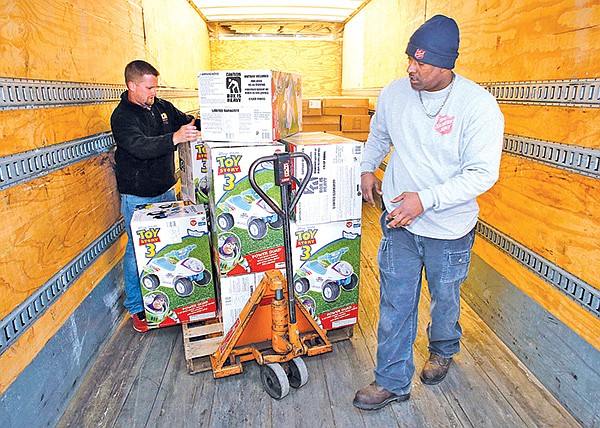 STAFF PHOTO DAVID GOTTSCHALK 
Michael Bahn, left, with Redman & Associates LLC and K.D. Graham, Salvation Army warehouse manager, unload 589 ride-on-top toys and scooters donated by Redman & Associates on Monday at one of two Salvation Army Angel Tree warehouses in Springdale. The Angel Tree program will begin distributing gifts and food this morning and Wednesday to more than 2,800 children in the Bentonville, Rogers, Springdale and Fayetteville areas.