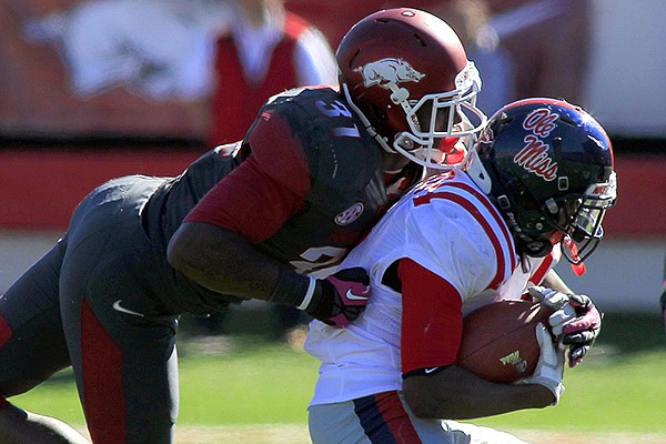 A.J. Turner tackles Ole Miss running back Jeff Scott during the 4th quarter of the Razorbacks 27-30 loss to Ole Miss on Saturday, Oct. 27, 2012 in Little Rock.