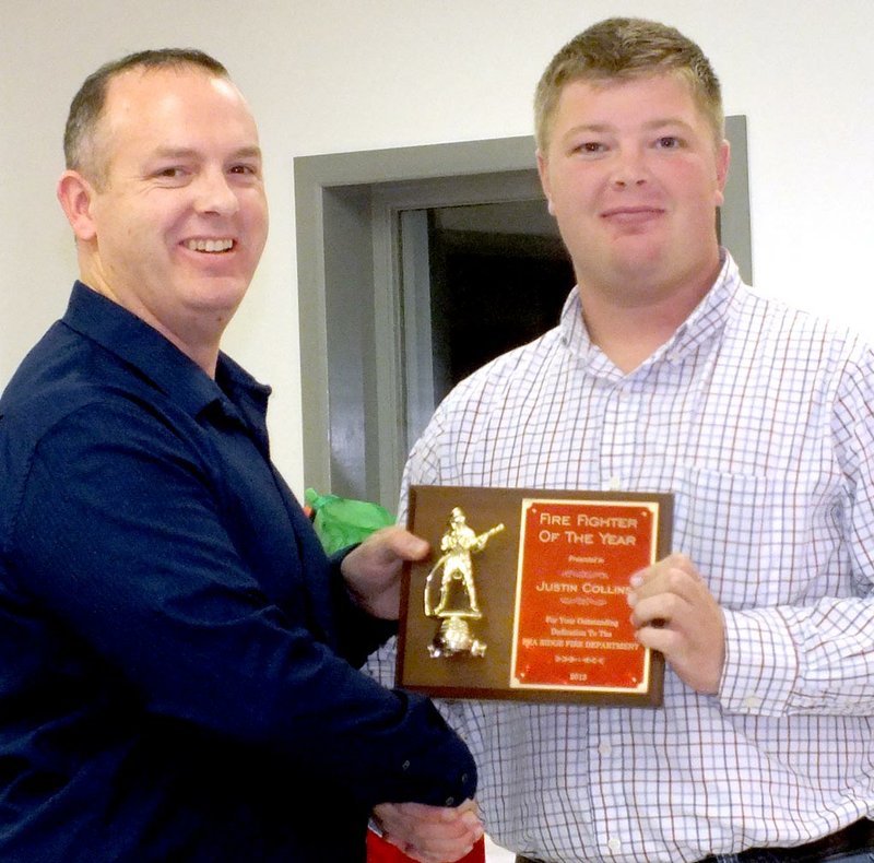 TIMES photographs by Annette Beard Justin Collins was awarded Firefighter of the Year by Pea Ridge Fire Chief Jamie Baggett at the annual Fire Department Christmas dinner Saturday.