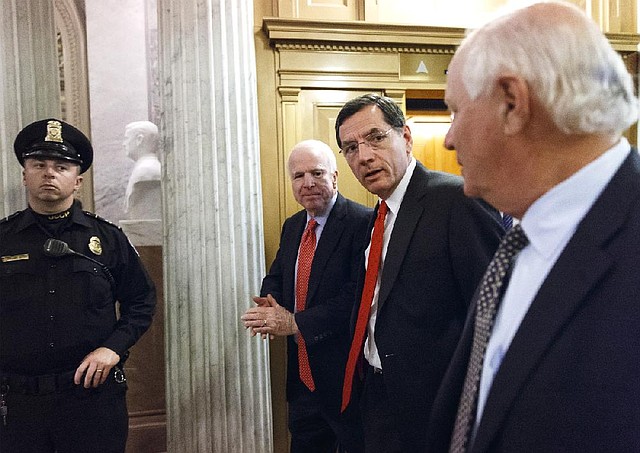 Republican Sens. John McCain (from center) of Arizona and John Barrasso of Wyoming and Democratic Sen. Ben Cardin of Maryland head to the Senate chamber Wednesday for final budget votes. 