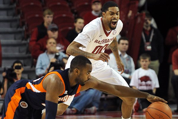Arkansas's Rashad Madden, right, and UT Martin's DeMarc Richardson chase after the ball after it got loose from Richardson during the first half of the basketball game in Bud Walton Arena in Fayetteville on Thursday December 19, 2013. 