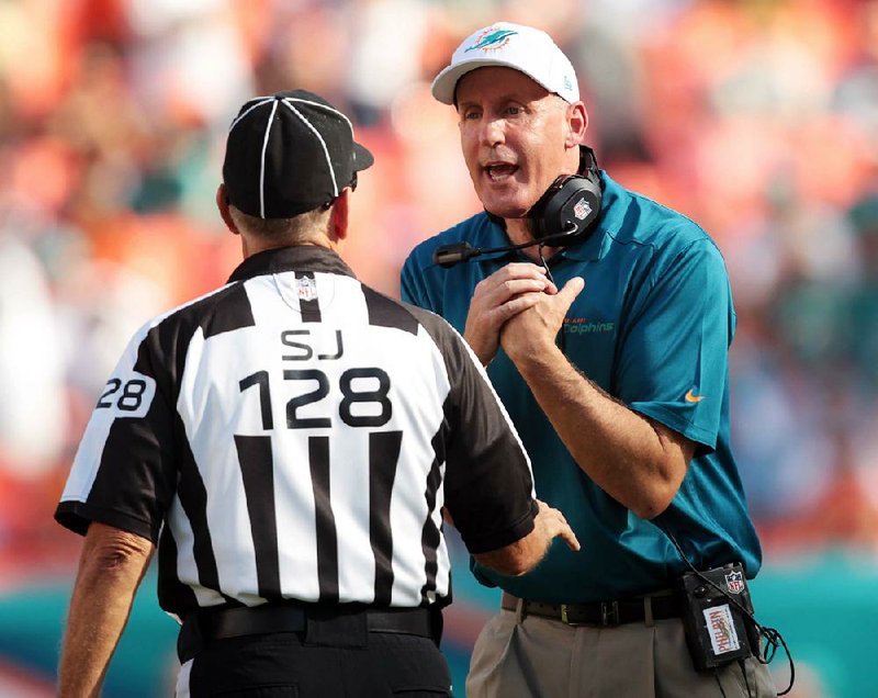 Miami Dolphins head coach Joe Philbin, right, speaks to side judge Larry Rose during the first half of an NFL football game against the Carolina Panthers, Sunday, Nov. 24, 2013, in Miami Gardens, Fla. (AP Photo/J Pat Carter)
