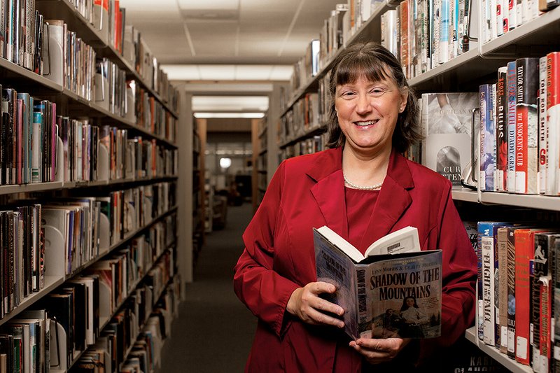 Tina Murdock, new director of the Faulkner-Van Buren County Library System, stands in the Conway library. Murdock said books, e-books, CDs and DVDS all have their place in public libraries. She said upgrading technology will be a goal for her first year with the library system, but she’ll also count on the public to let her know what they’d like to see improved.