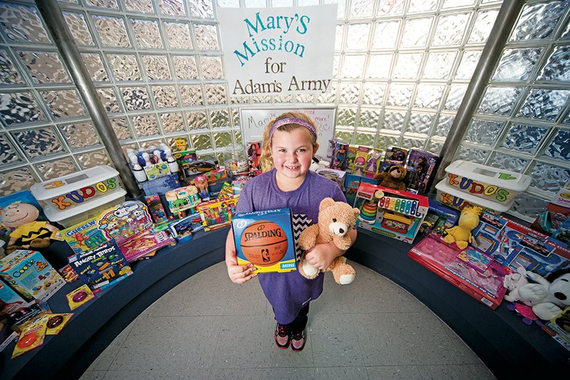 Mary Melton, 9, a fourth-grader at Jim Stone Elementary School in Conway, stands with toys collected through a project she spearheaded called Mary’s Mission for Adam’s Army. Mary said she saw a video about patients at Arkansas Children’s Hospital in Little Rock and decided to ask students to bring toys and books to donate to the kids.