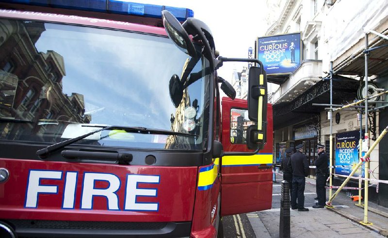 A fire brigade truck waits outside The Apollo Theatre in London, Friday, Dec. 20, 2013. Authorities are carrying out a structural assessment at the Apollo Theatre after the partial collapse of its ceiling injured more than 75 people in the packed auditorium. An initial report is expected Friday after an overnight survey. The building remains cordoned off after the incident happened during the evening performance of "The Curious Incident Of The Dog In The Nighttime." (AP Photo/Alastair Grant)